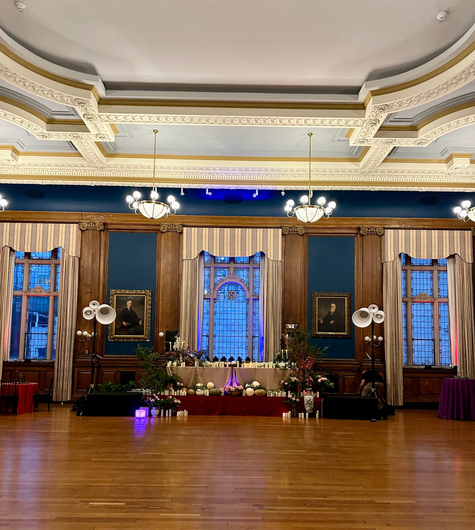 The Mütter Museum ballroom with its ornate ceiling, Void horns on stands either side of a candlelit table